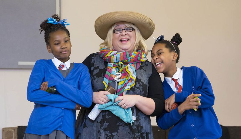 Two school children and a woman posing on stage at the Your Voice, Your Choice event.