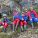 Group of young people dressed in outdoor gear sitting on a rock.