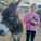 A young girl standing next to a donkey and holding its reins.