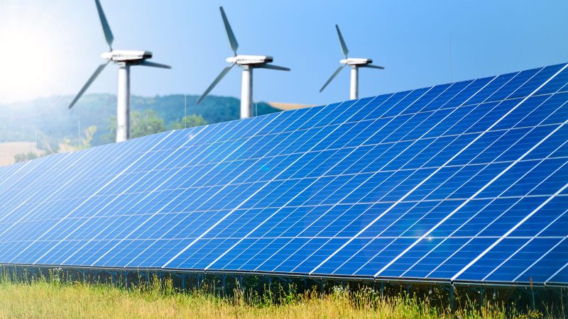 PBS Retrofit Wind turbines and solar panels in a countryside area.
